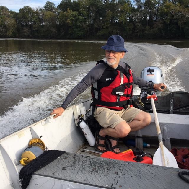 The author is pictured here with five elements of boating safety (especially power-boating safety): a life jacket, a fire extinguisher (in case of fire caused by gasoline spill), a rescue rope throw bag, an auxiliary propulsion source (a paddle), and an emergency engine cutoff lanyard. Courtesy Bob Sargeant.